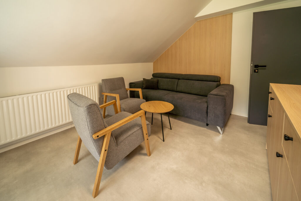 Obývacia časť apartmánu so sedačkou a kreslami