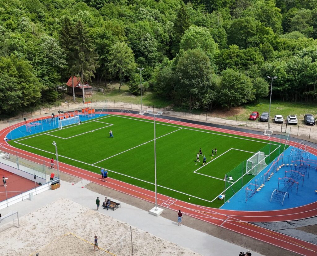 Futbalové ihrisko s atletickou dráhou uprostred lesa